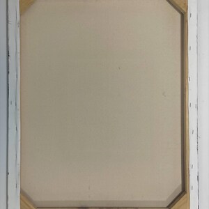 Puede incluir: Parte trasera de una obra de arte en lienzo estirado. El lienzo es de color beige claro, estirado sobre un marco de madera. El marco es visible, con lona blanca grapada a la madera. Los bordes del marco est&aacute;n pintados de negro.