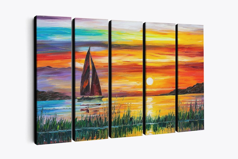 May include: A five-panel canvas art piece depicting a sunset over water. The artwork features a sailboat with brown sails, a vibrant orange and yellow sky, and a reflection of the scene in the water. Green reeds are in the foreground.