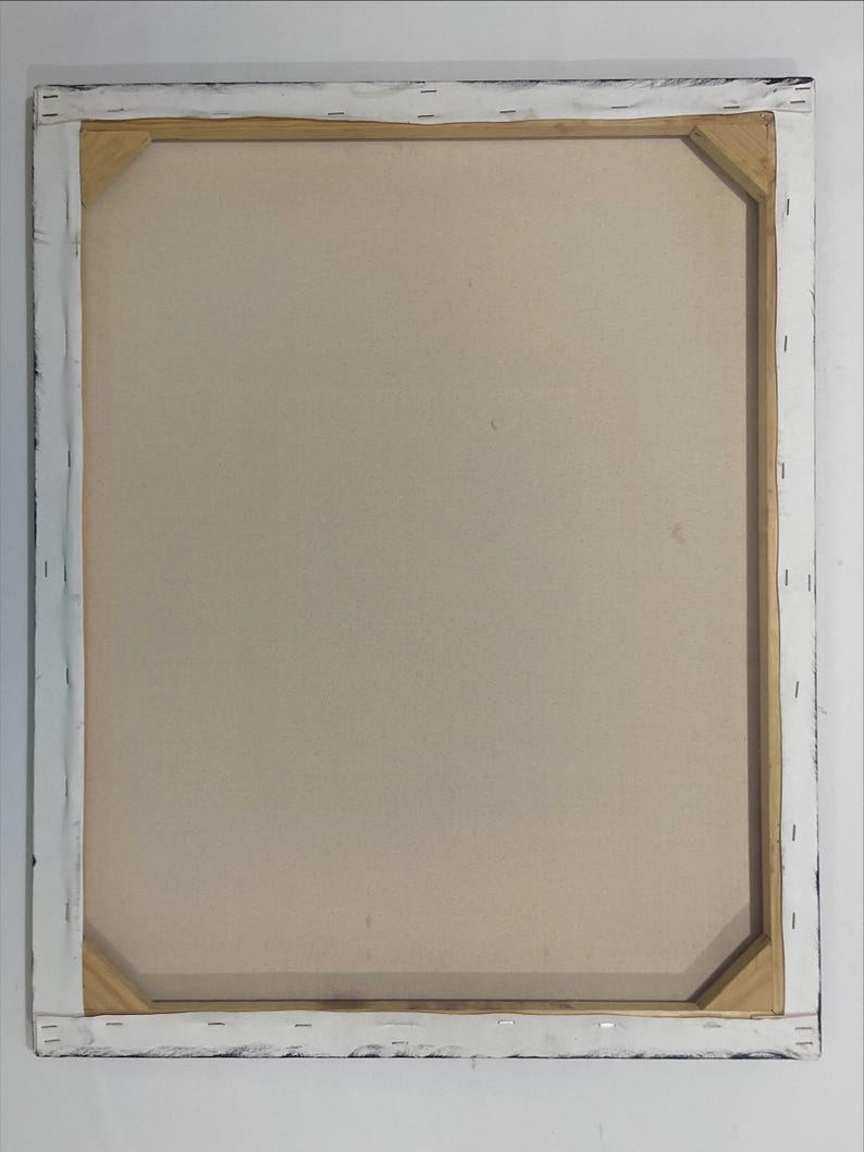 May include: Back of a stretched canvas art piece. The canvas is a light beige color, stretched over a wooden frame. The frame is visible, with the canvas wrapped around the edges and stapled to the wood. The edges of the frame are painted black.