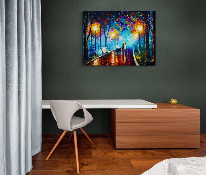 May include: A colorful oil painting depicts a romantic scene of a couple walking in a park at night. The artwork features vibrant hues of blue, orange, and yellow, with reflections on the wet pavement. The painting is displayed on a dark green wall above a white desk.