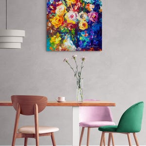 May include: An abstract floral painting with vibrant colors. The artwork features a bouquet of roses in shades of yellow, orange, and pink against a deep blue background. The painting hangs above a wooden table with chairs.