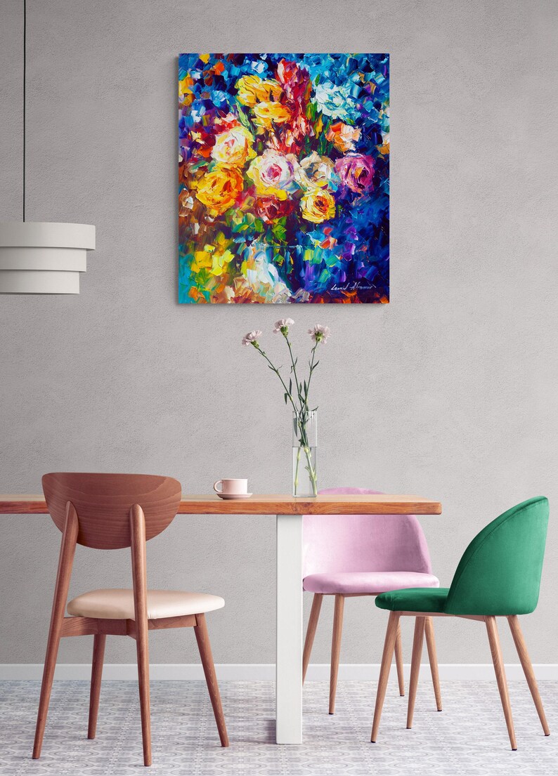May include: An abstract floral painting with vibrant colors. The artwork features a bouquet of roses in shades of yellow, orange, and pink against a deep blue background. The painting hangs above a wooden table with chairs.