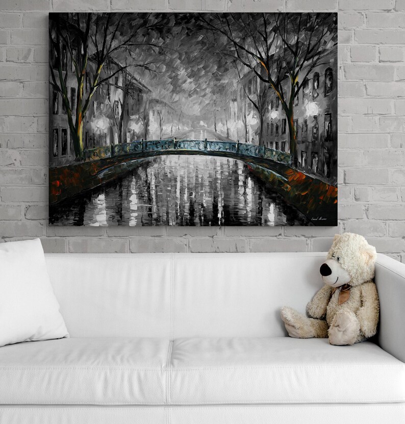 May include: A large canvas print of a nighttime cityscape in shades of gray, black, and orange. The artwork depicts a bridge over a canal, with buildings and trees lining the water's edge. The painting has a textured, impressionistic style.