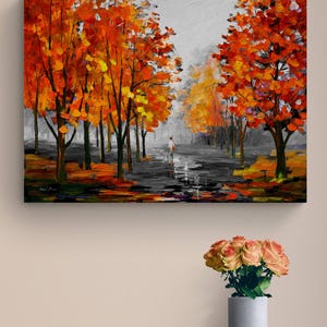 May include: An oil painting depicts a path lined with trees in autumn. The trees have vibrant orange and yellow leaves, contrasting with the gray sky and path. A figure walks in the distance, adding a sense of scale and depth to the artwork.