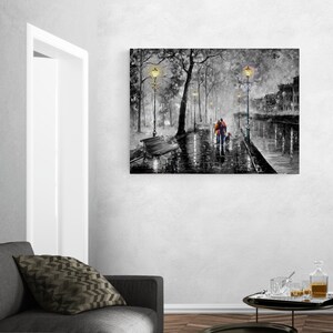 Puede incluir: Impresi&oacute;n art&iacute;stica en lienzo en blanco y negro que representa una escena de parque lluvioso con una pareja y un perro caminando por un sendero mojado. La obra presenta farolas, &aacute;rboles y edificios, con un toque de color en la ropa de las figuras.