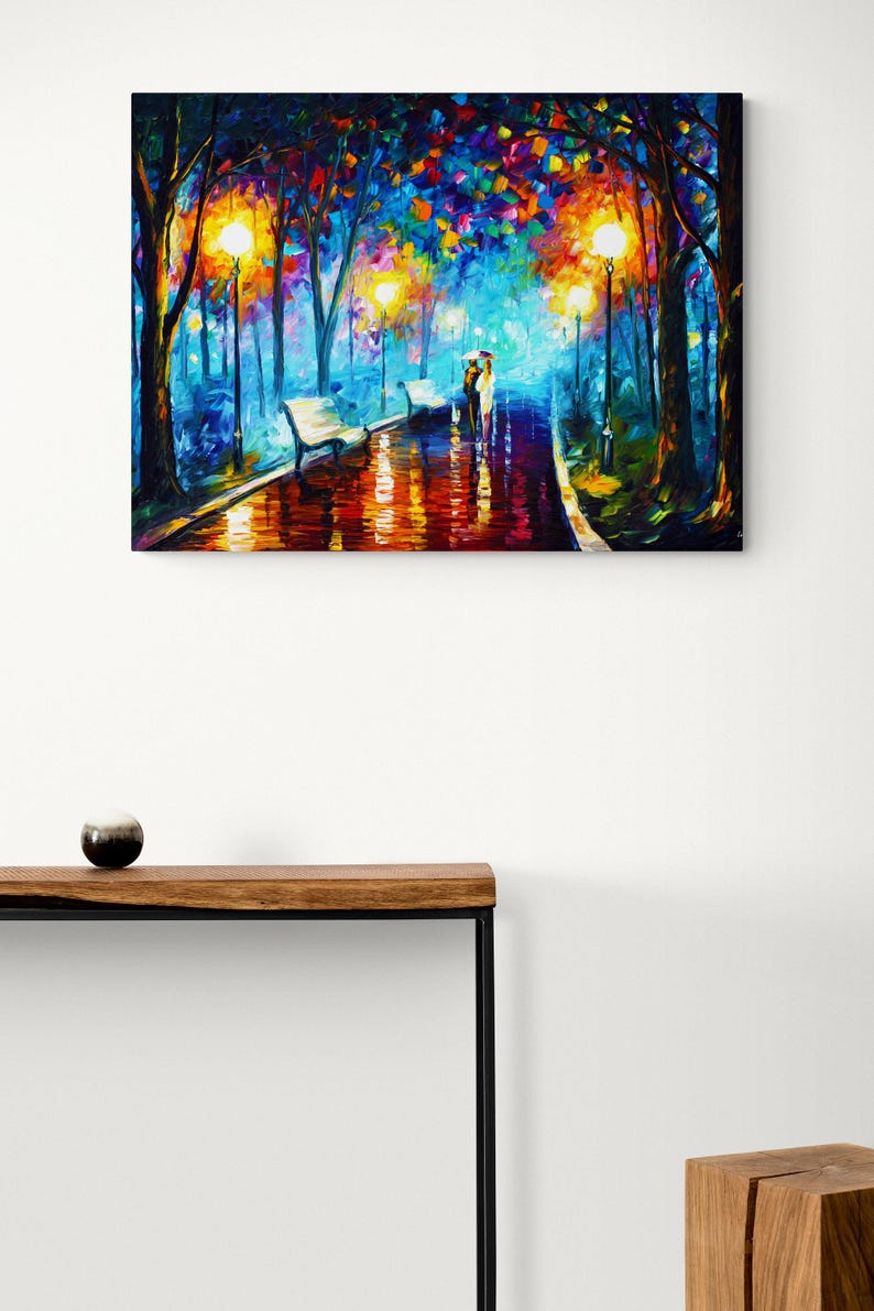 May include: A colorful oil painting depicts a park scene at night. The artwork features a couple walking under an umbrella on a wet path, illuminated by streetlights and surrounded by trees with vibrant foliage. Benches line the path.