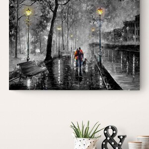 Puede incluir: Pintura en blanco y negro de una pareja caminando con un perro por una calle mojada, iluminada por farolas. La obra presenta una paleta de grises con toques de color en la ropa de la pareja, creando una escena rom&aacute;ntica y atmosf&eacute;rica.