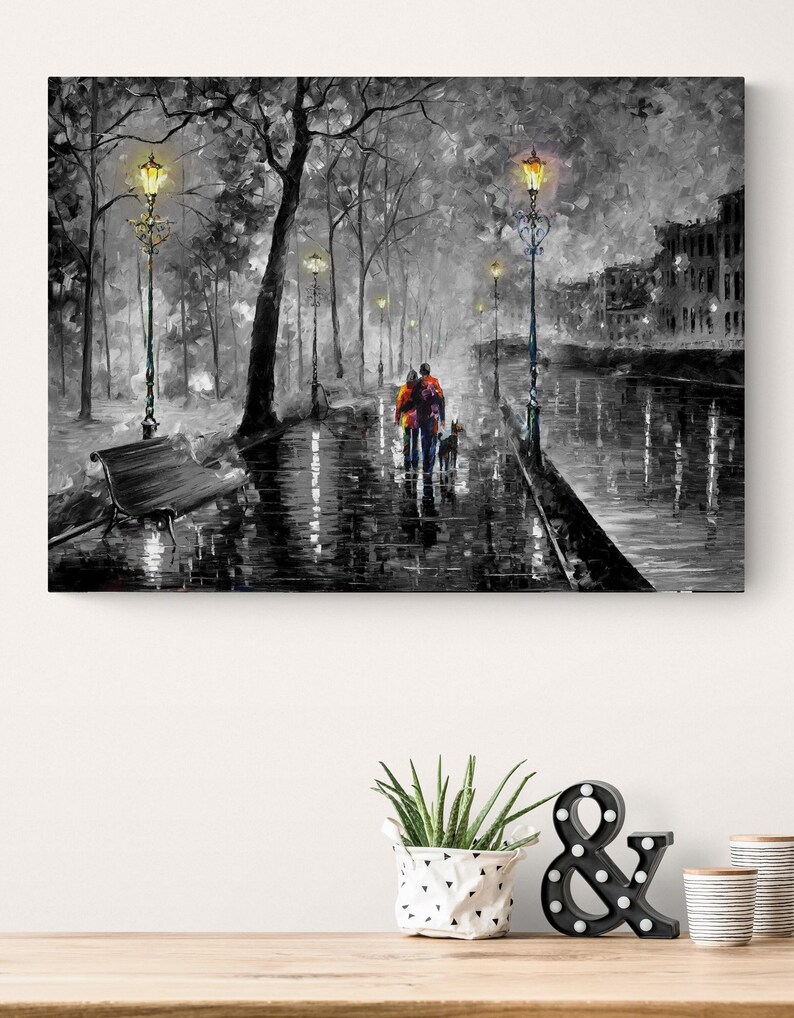 Puede incluir: Pintura en blanco y negro de una pareja caminando con un perro por una calle mojada, iluminada por farolas. La obra presenta una paleta de grises con toques de color en la ropa de la pareja, creando una escena rom&aacute;ntica y atmosf&eacute;rica.