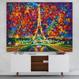 Pu&ograve; includere: Un dipinto vibrante e impressionistico della Torre Eiffel a Parigi, Francia, con uno stile colorato e astratto. L'opera presenta l'iconica torre illuminata contro uno sfondo di pennellate vivaci e colorate. Il dipinto &egrave; esposto sopra un mobile bianco.