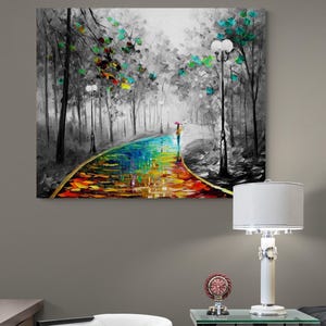 May include: A colorful oil painting depicts a path through a black and white forest. The path is a vibrant rainbow of colors, with a person holding an umbrella. Trees with colorful leaves line the path.