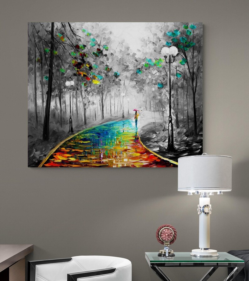 May include: A colorful oil painting depicts a path through a black and white forest. The path is a vibrant rainbow of colors, with a person holding an umbrella. Trees with colorful leaves line the path.