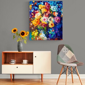 May include: An abstract floral painting with vibrant colors, including yellow, orange, and pink roses, hangs on a gray wall. A modern cabinet with a vase of sunflowers and a patterned chair complete the room's decor.