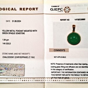 May include: Gemological report for a yellow metal pendant with a green opaque gemstone. The report states the stone is chalcedony (chrysoprase) weighing 7.10 carats. The report number is 14732C33880 and the date is 31.08.2024.