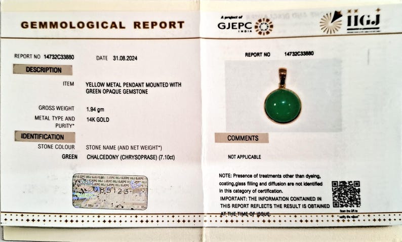 May include: Gemological report for a yellow metal pendant with a green opaque gemstone. The report states the stone is chalcedony (chrysoprase) weighing 7.10 carats. The report number is 14732C33880 and the date is 31.08.2024.