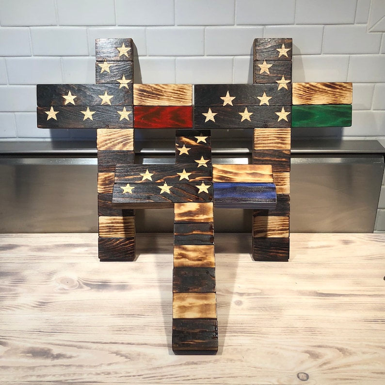 K&ouml;nnte beinhalten: Drei Holzkreuze, jedes mit einem anderen amerikanischen Flaggen-Design. Das obere Kreuz hat ein traditionelles amerikanisches Flaggen-Design, das mittlere Kreuz hat eine d&uuml;nne rote Linie und das untere Kreuz hat eine d&uuml;nne blaue Linie.