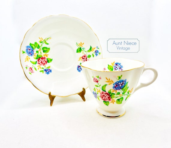Vintage teacup and saucer pink and blue flowers lilacs yellow floral scalloped shaped pedestal cup gold accents c. 1950s