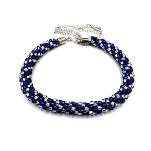 May include: A blue and silver beaded necklace with a silver chain and clasp.
