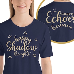 May include: Navy blue t-shirt with gold glitter text that reads "happy Shadow thoughts" on the front and "angry Echoes beware" on the back.