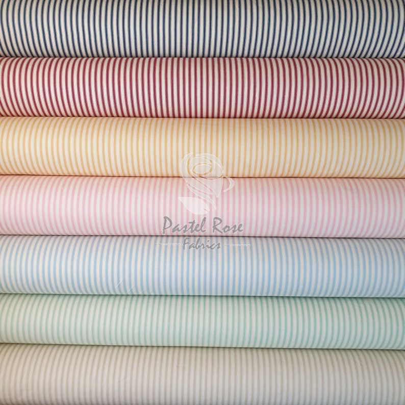 May include: A stack of striped fabric rolls in various colors, including navy blue, red, yellow, pink, light blue, green, and cream. The fabric is a classic striped pattern with thin white stripes.