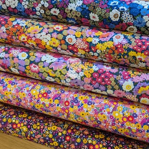 May include: Five rolls of colorful floral patterned fabric. The fabric features a variety of flowers in different colors and sizes, including pink, yellow, blue, and green.