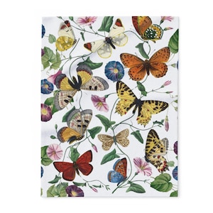 May include: A white fabric featuring a repeating pattern of various butterflies in shades of orange, yellow, red, and brown, interspersed with green vines, leaves, and pink and purple morning glory flowers across the entire surface.