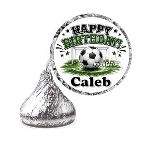 May include: A silver foil-wrapped chocolate candy with a circular sticker featuring a soccer ball, a goal, and the text HAPPY BIRTHDAY! PP CREATION and Caleb. The design includes green grass, black and white soccer ball, and dark green lettering.