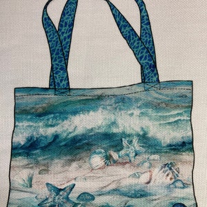 May include: A blue and white tote bag with a beach scene featuring seashells, starfish, and waves. The bag has blue patterned straps.