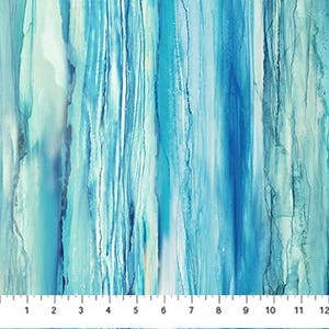 May include: Fabric with a watercolor effect in shades of blue and teal. Vertical streaks of color create a flowing, abstract pattern. The fabric has a light, airy appearance, with a ruler at the bottom showing inch measurements.