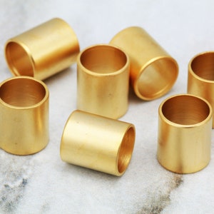 Puede incluir: Un conjunto de siete anillos de metal de color dorado. Los anillos son todos del mismo tama&ntilde;o y forma, y est&aacute;n dispuestos en c&iacute;rculo.