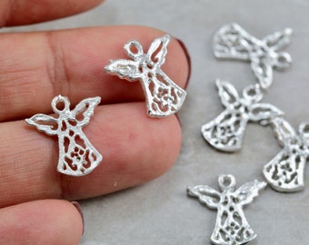 Puede incluir: Encantos de ángel plateados con diseños calados. Los amuletos tienen alas y un halo, ideales para la fabricación de joyas u otros proyectos de artesanía. Los ángeles son pequeños y delicados, con detalles intrincados.