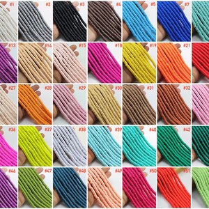 May include: A collection of 52 strands of colorful polymer clay beads. Each strand is numbered and features a different color. The beads are small and cylindrical, with a slightly rounded shape.