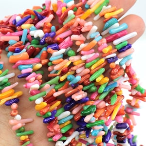 May include: A strand of colorful coral beads, featuring a variety of shapes and sizes. The beads are a mix of bright colors, including red, orange, yellow, green, blue, and purple.