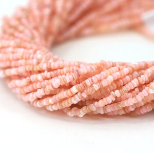 May include: A strand of pink opal beads, each bead is a small, irregular shape with a slightly rough texture.