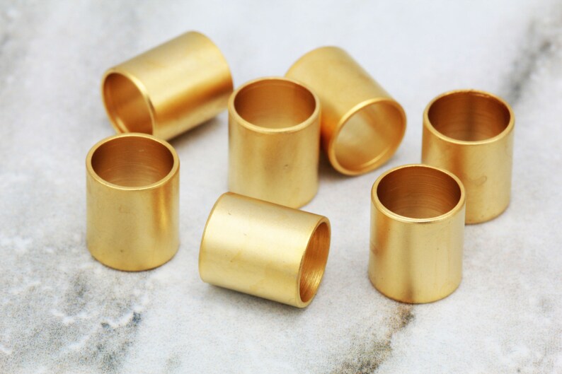 Puede incluir: Un conjunto de siete anillos de metal de color dorado. Los anillos son todos del mismo tama&ntilde;o y forma, y est&aacute;n dispuestos en c&iacute;rculo.