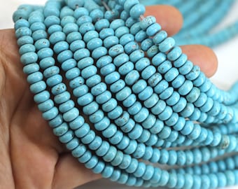 May include: A strand of turquoise beads, each bead is a light blue color with a slightly rough texture. The beads are round and have a slightly irregular shape.