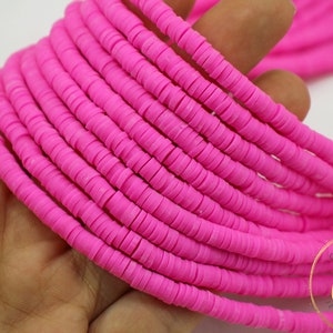 May include: A strand of bright pink round polymer clay beads. The beads are approximately 6mm in diameter and have a matte finish.
