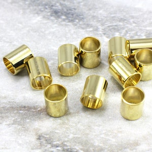 Puede incluir: Un grupo de 12 tapones de extremo de metal de color dorado para la elaboraci&oacute;n de joyas. Los tapones de extremo son cil&iacute;ndricos y tienen un acabado liso y brillante.