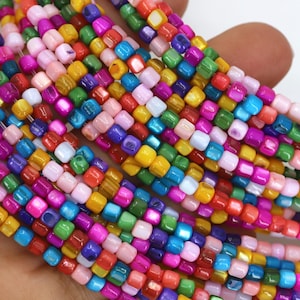 May include: Strands of colorful square beads in a variety of colors including pink, blue, green, yellow, and purple. The beads are strung together, creating a vibrant and eye-catching display. Ideal for jewelry making.