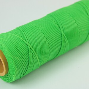 May include: A spool of bright green waxed cotton thread.