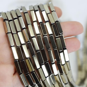 May include: A strand of silver-toned rectangular hematite beads. The beads are smooth and have a metallic sheen.