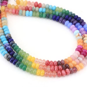 Peut inclure: Un brin de perles rondes en pierres précieuses multicolores. Les perles sont disposées en arc-en-ciel, chaque couleur étant représentée par un type de pierre précieuse différent.