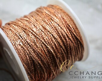 May include: A spool of rose gold colored chain, perfect for jewelry making. The chain is made of small, flat links and has a subtle shimmer.