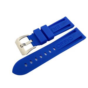 K&ouml;nnte beinhalten: Ein blaues Gummiband f&uuml;r eine Uhr mit einer silbernen Schlie&szlig;e. Das Band hat die W&ouml;rter "ERA" und "OFFIC" gepr&auml;gt.