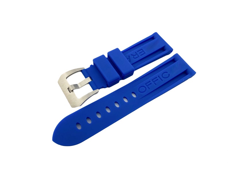 K&ouml;nnte beinhalten: Ein blaues Gummiband f&uuml;r eine Uhr mit einer silbernen Schlie&szlig;e. Das Band hat die W&ouml;rter "ERA" und "OFFIC" gepr&auml;gt.