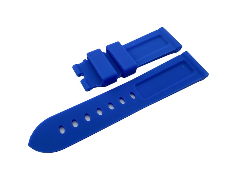 K&ouml;nnte beinhalten: Ein leuchtend blaues Silikon-Armband mit einer Schlie&szlig;e und L&ouml;chern zum Einstellen der Passform.