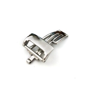 May include: A silver watch band clasp with a polished finish.