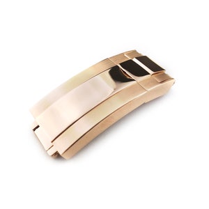 K&ouml;nnte beinhalten: Ein goldfarbener Uhrenarmbandverschluss mit polierter Oberfl&auml;che.