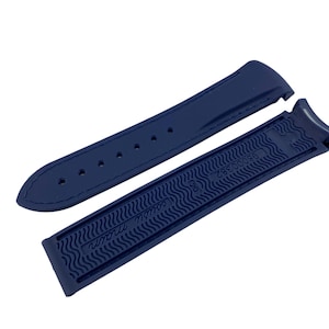 May include: A dark blue rubber watch strap with a textured pattern and the text "Swiss Made" on the underside.