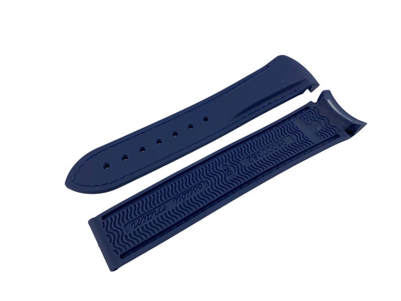 May include: A dark blue rubber watch strap with a textured pattern and the text "Swiss Made" on the underside.