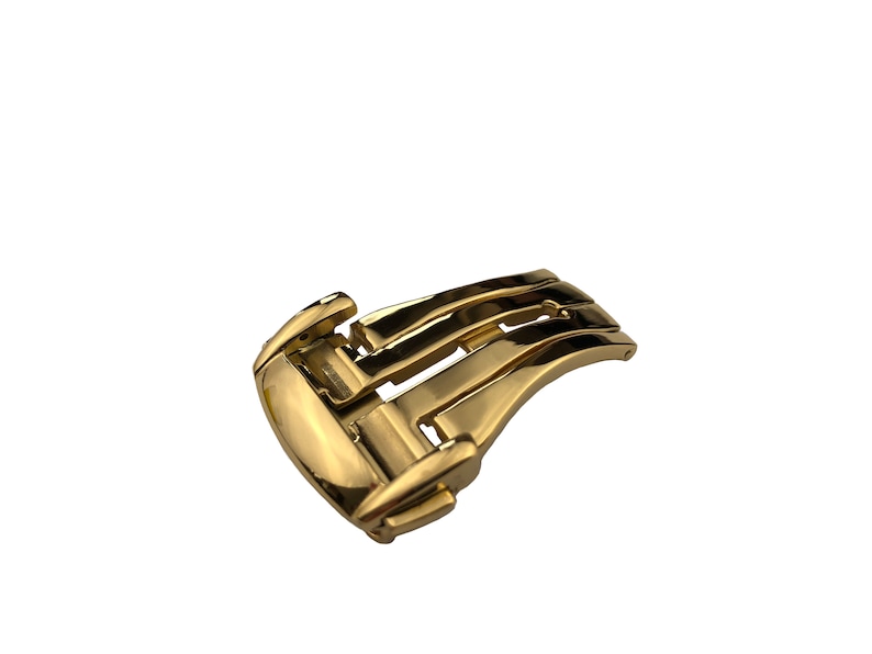 May include: A gold-toned metal watch band buckle with a deployment clasp.